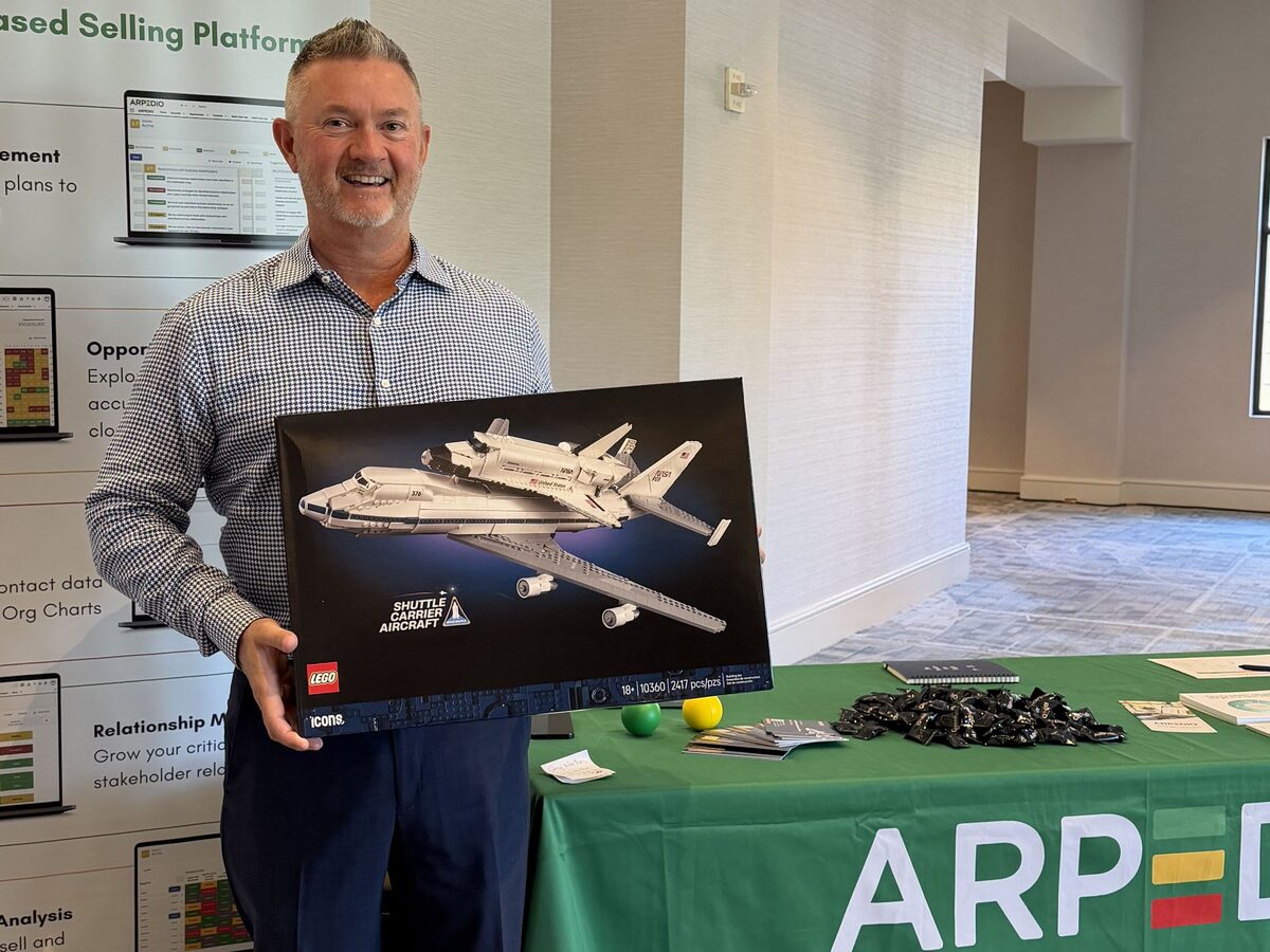 ARPEDIO booth at SAMA Annual 2026, Phoenix — team member holding the Lego space shuttle competition prize